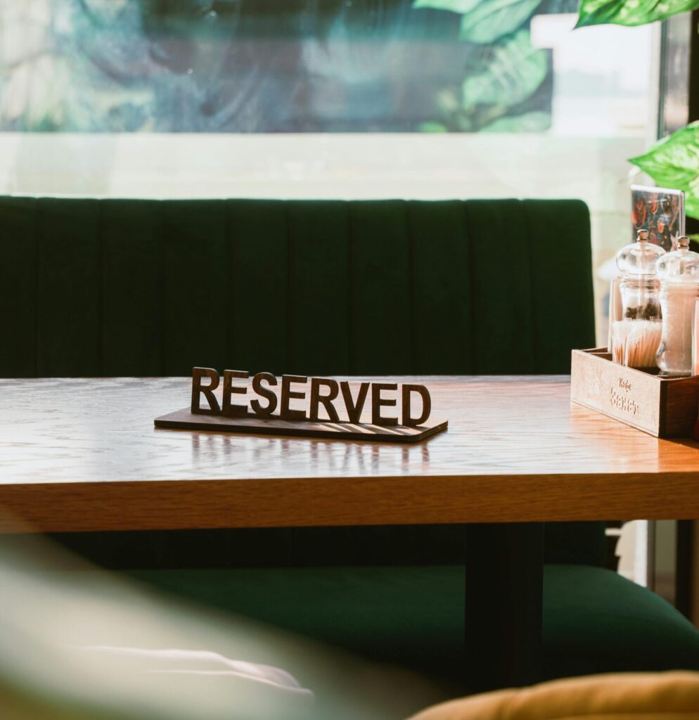 Interior shot of a modern café with a reserved sign on a wooden table, bathed in natural light.
